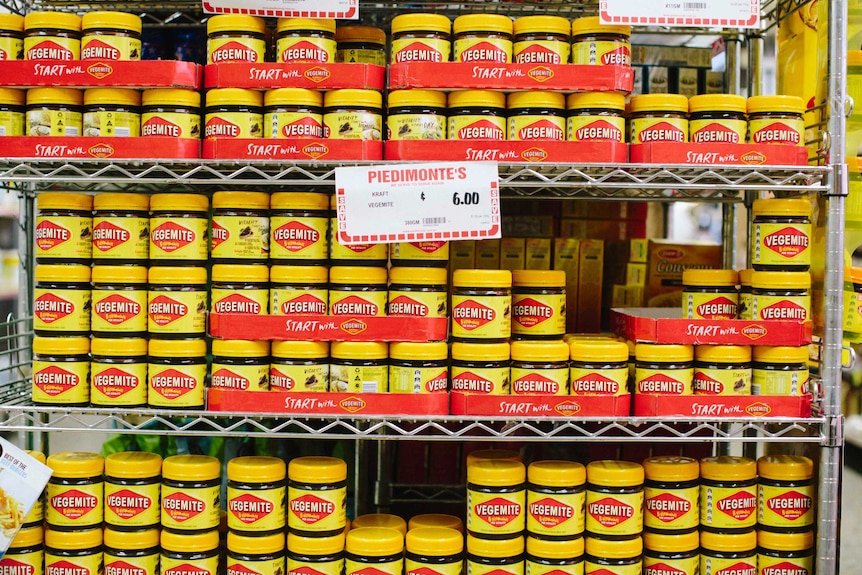 A shelf full of vegemite jars.