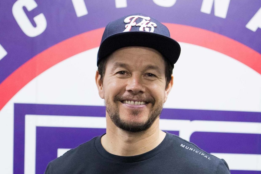 A smiling man wearing a baseball cap and a t-shirt. 