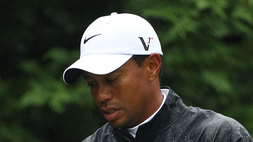 Woods' slim chances of winning faded in the rain.