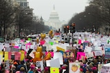 From a high point, a photograph shows throngs of protesters down Pennsylvania Av with the US Capitol building on the horizon.