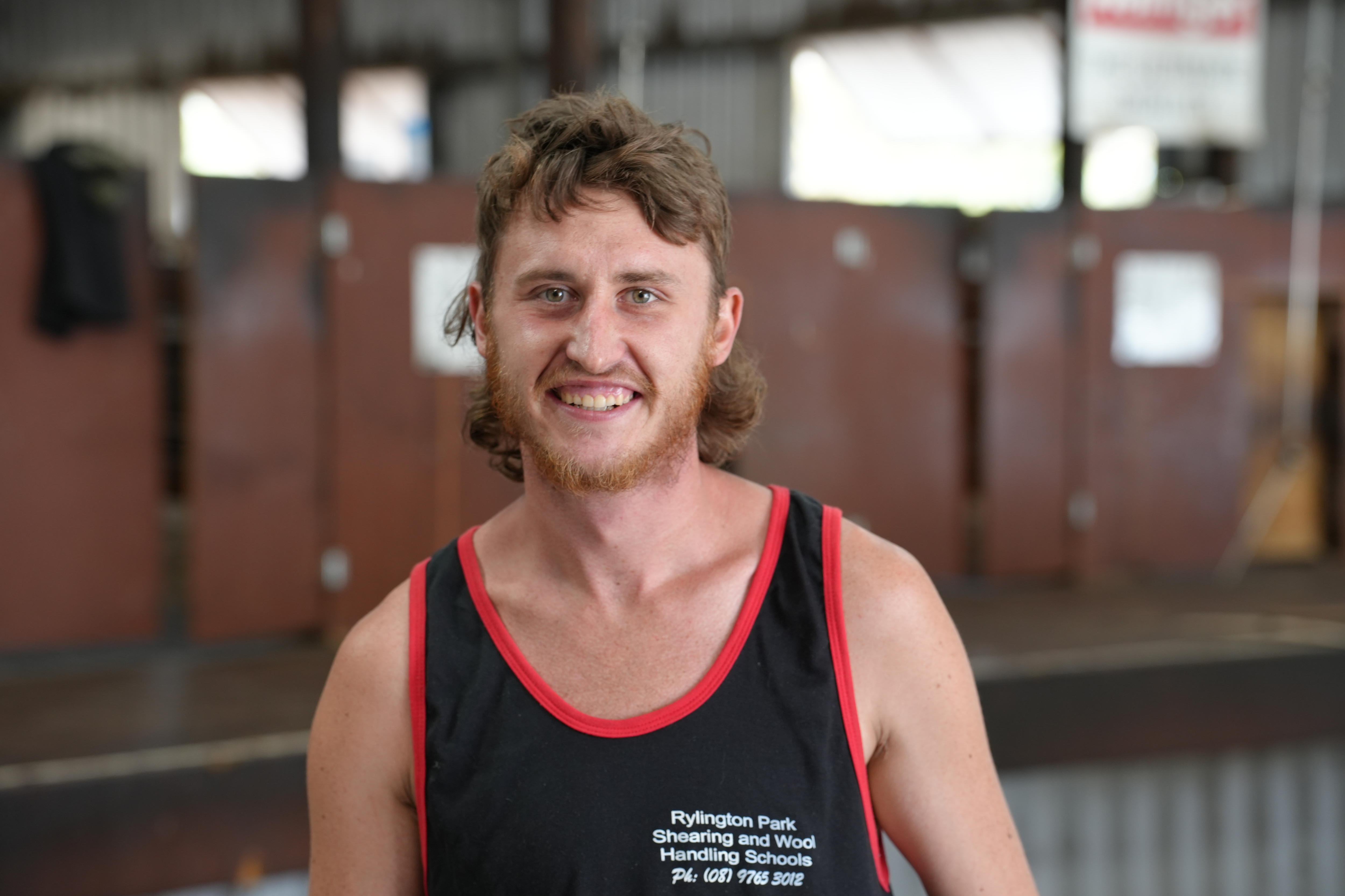 a man with a mullet in a blue singlet 