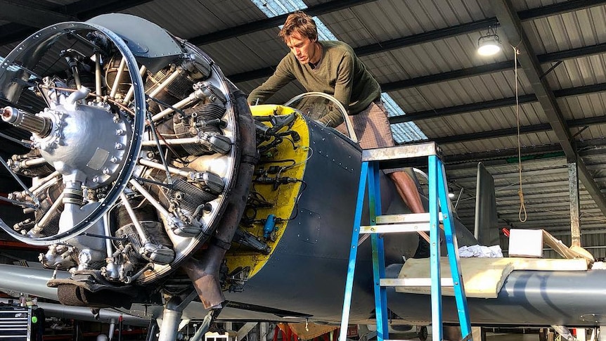 Anatole Mills working on a plane's engine
