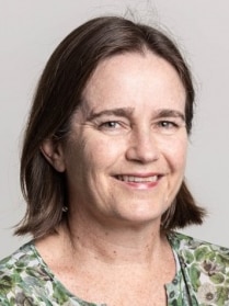 Head and shoulders image of brunette-haired woman smiling.