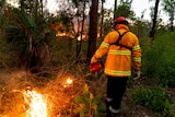 A firefighter starting backfires in the NT.