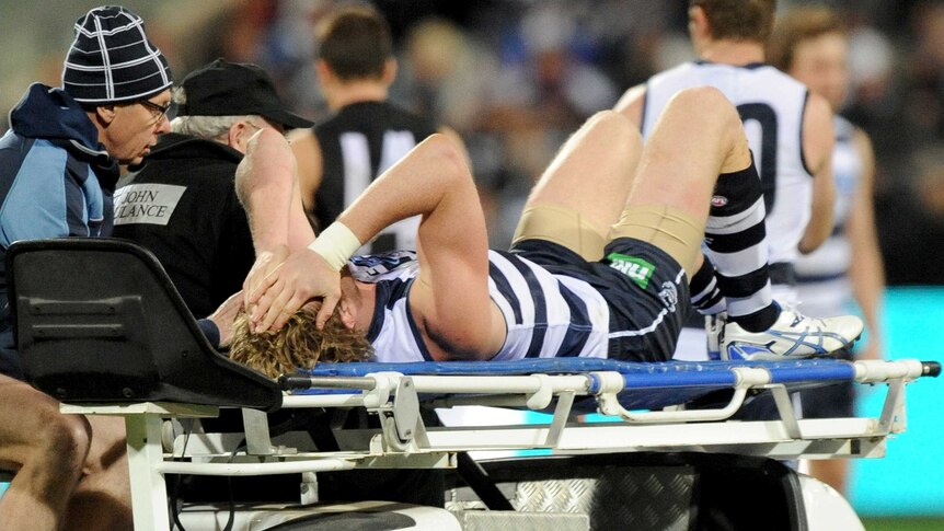 Geelong's Dawson Simpson is taken off the ground on a stretcher after injuring his knee.