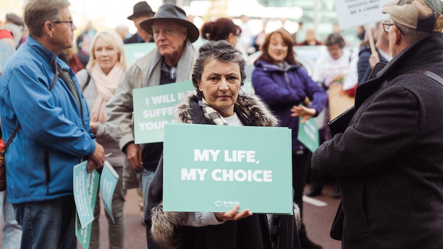 Voluntary euthanasia supporter holds a "My Life, My Choice" sign.