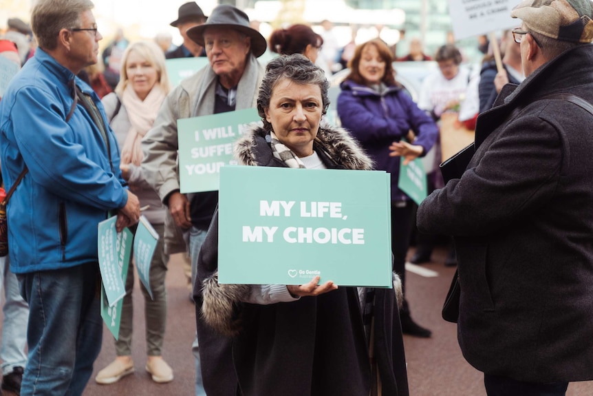 Voluntary euthanasia supporter holds a "My Life, My Choice" sign.