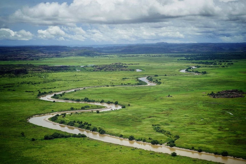 A river snakes through green bushland in Kakadu National Park. 