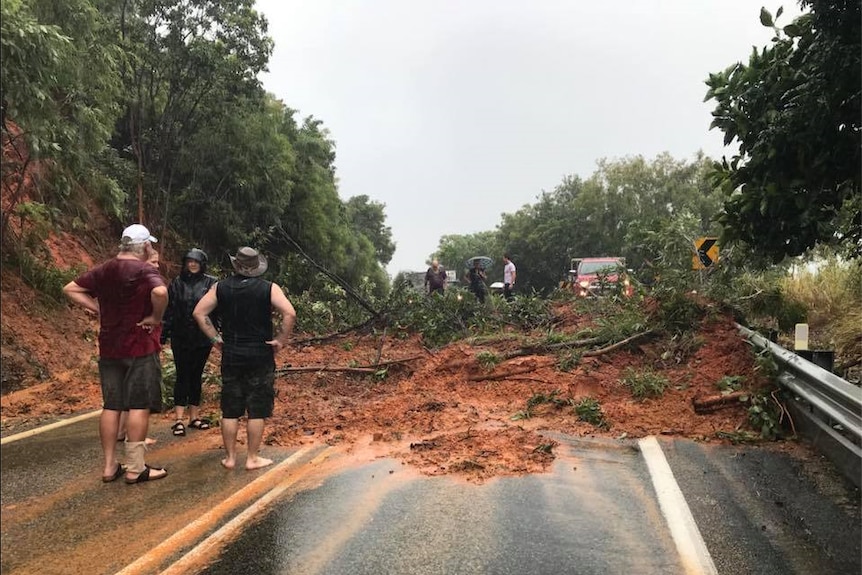 Mud and trees cover the road after a landslide