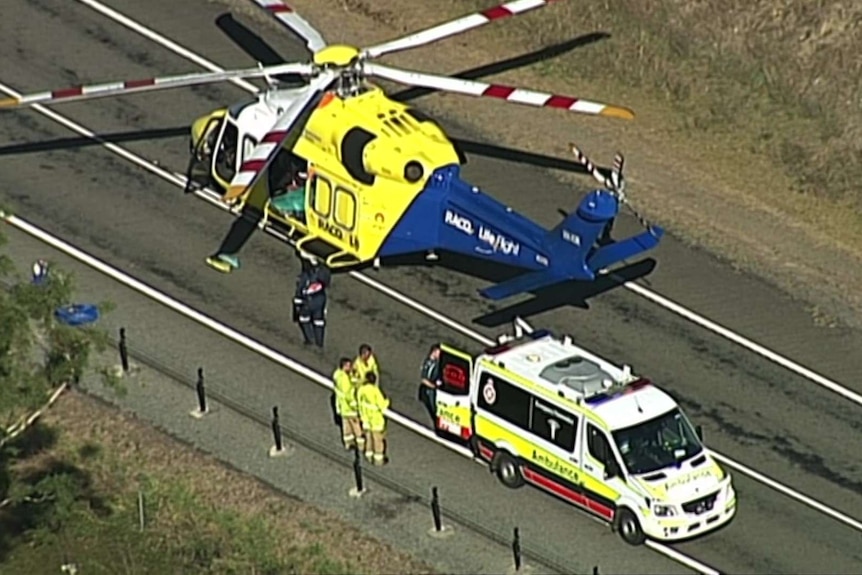 An ambulance vehicle next to an RACQ rescue helicopter