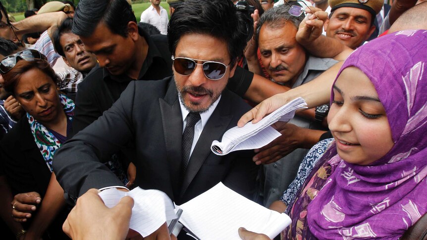 Fans try to get autographs by Bollywood actor Shah Rukh Khan.