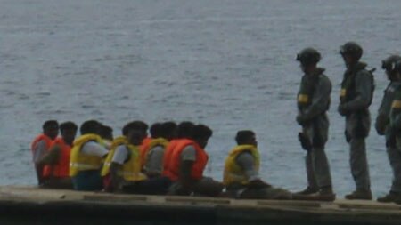 The Navy guards Sri Lankan asylum seekers on a boat. (ABC TV)
