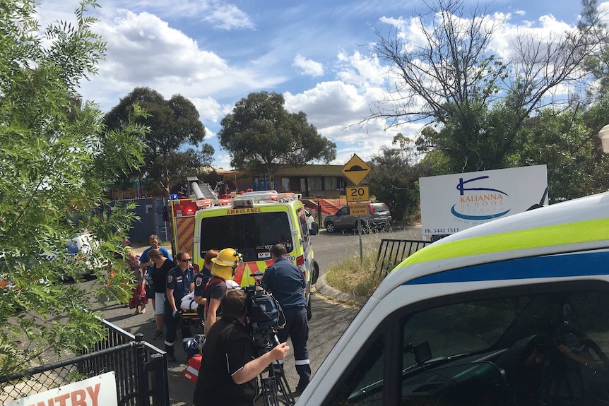 Paramedics attend to victims after they were freed from underneath a fallen tree branch in Bendigo.