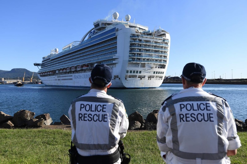 two police rescue officers looking at a cruise in a harbour