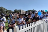 People waving Australia flags in Canberra to watch Australian citizenship ceremonies.