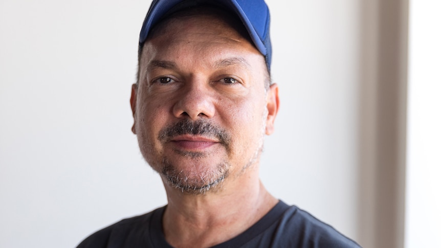 Headshot of Stephen Page wearing a blue cap
