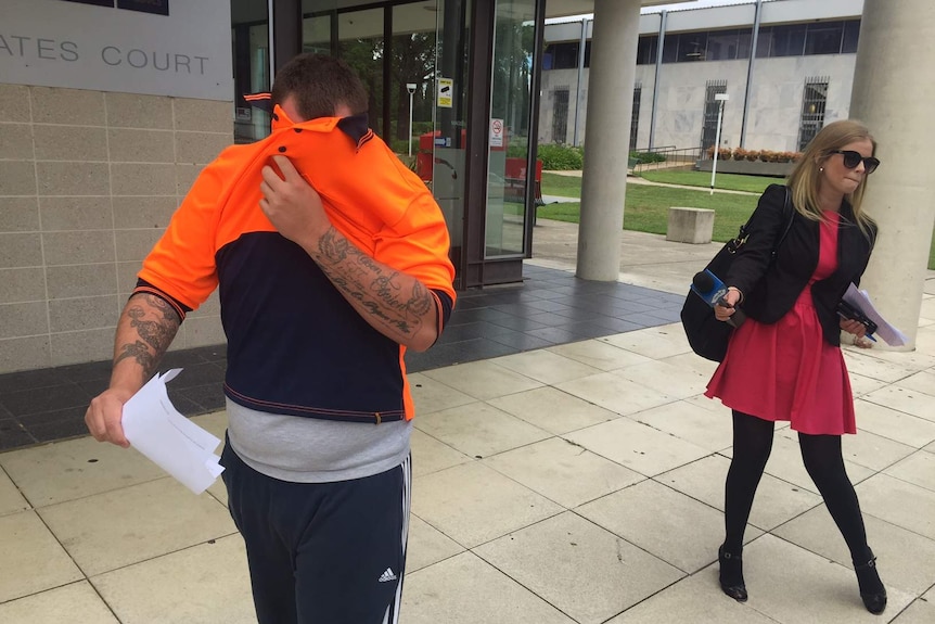 Harley Stott covers his face after appearing in the ACT Magistrates Court in February.