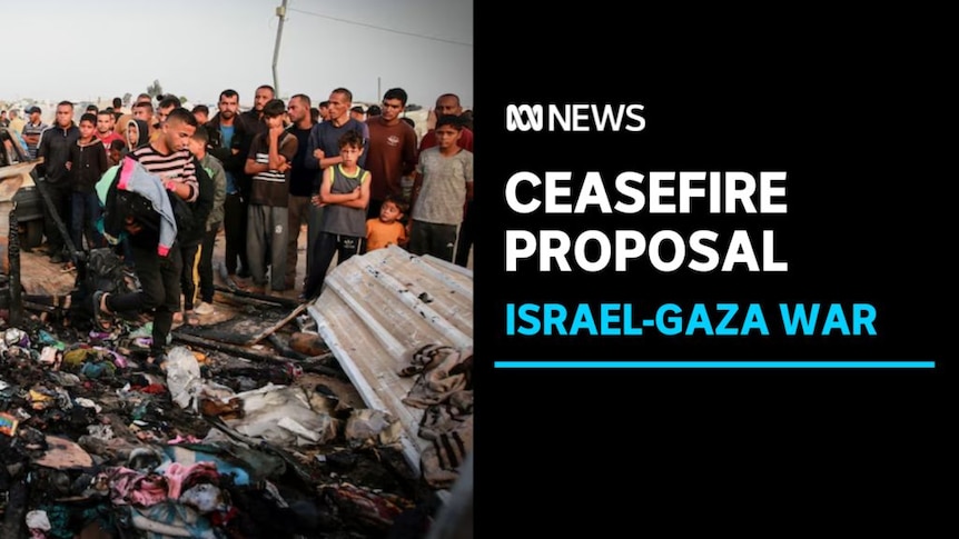 Ceasefire Proposal, Israel-Gaza War: People stand around a damaged scene while a man gathers up clothes.