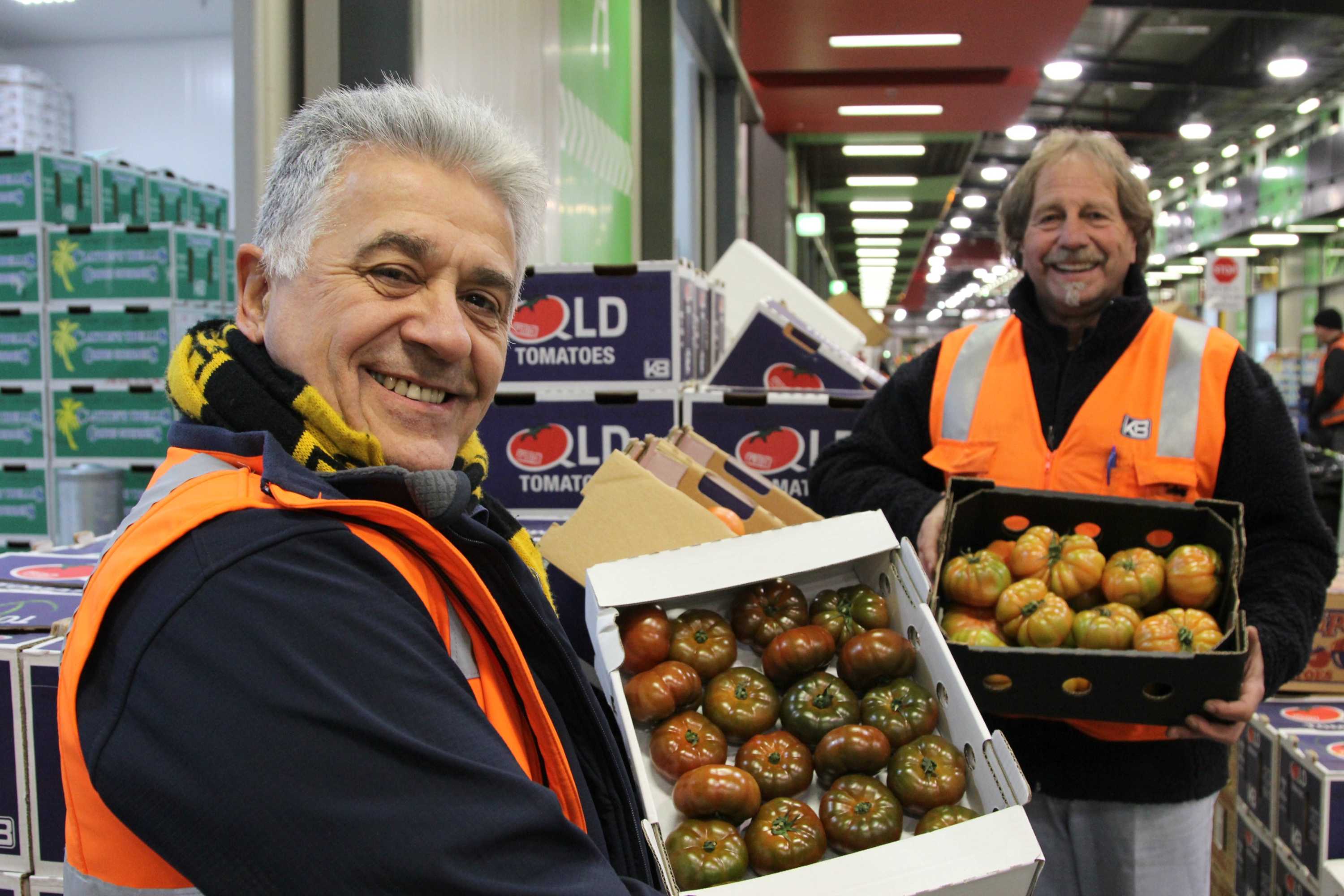 Harry Kapiris (left) and Frank Mileto hold boxes of tomatoes at the Melbourne Markets.