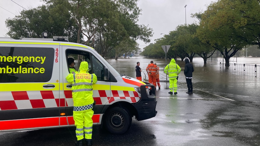 emergency personnel standing next to a flooded area