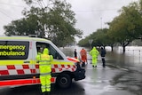 emergency personnel standing next to a flooded area