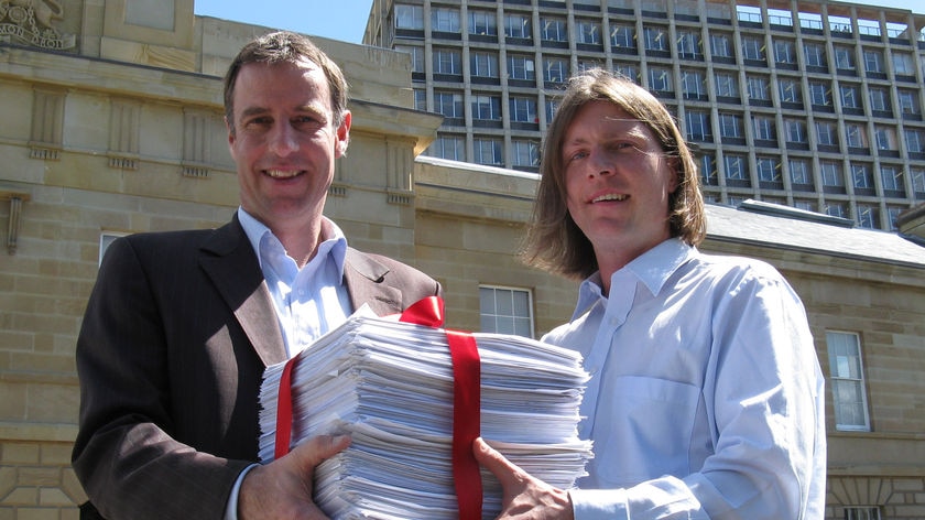 Battery hen campaigner Ben Bartl presents Greens leader Nick McKim with the petition.