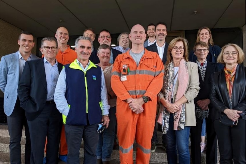 group of people, one man in orange high vis outfit