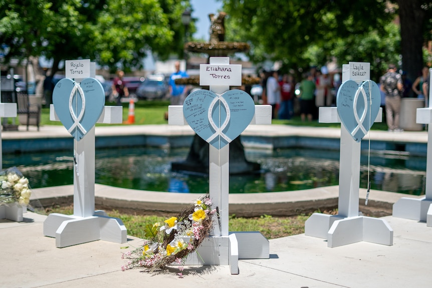 White crosses with blue hearts are set up at a memorial in Uvalde, Texas