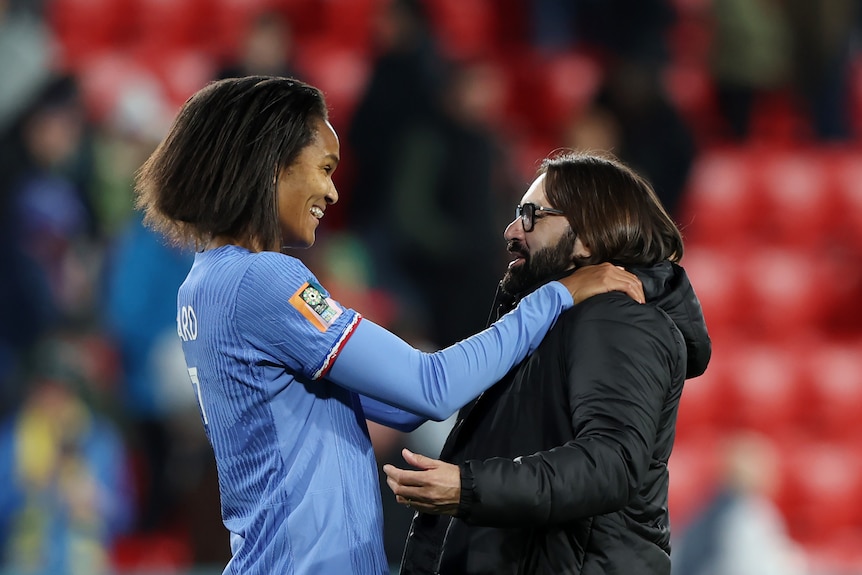 French player Wendie Renard smiles and embraces Morocco coach Reynald Pedros at the FIFA Women's World Cup.