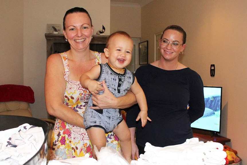 Raelene Edmundson with her one-year-old son Jayden in her Cairns house, and Victoria Rose.