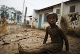 A child sits on mud caused by Typhoon Ketsana in Montalban Rizal, west of Manila on October 2, 2009.