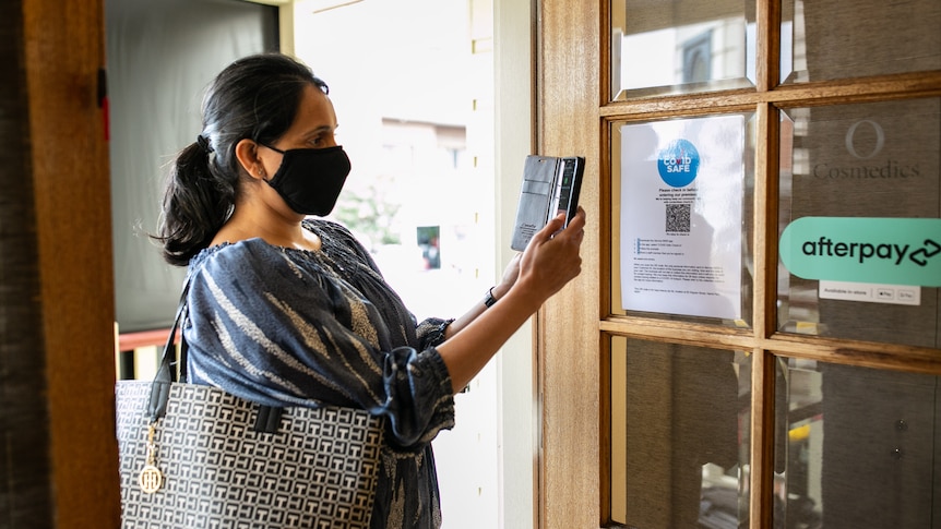 woman scans in using QR code