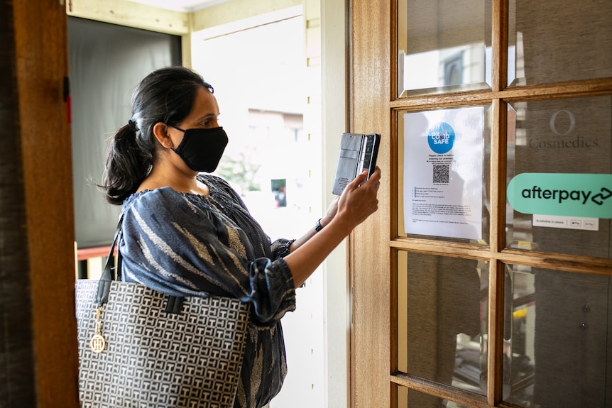 woman scans in using QR code