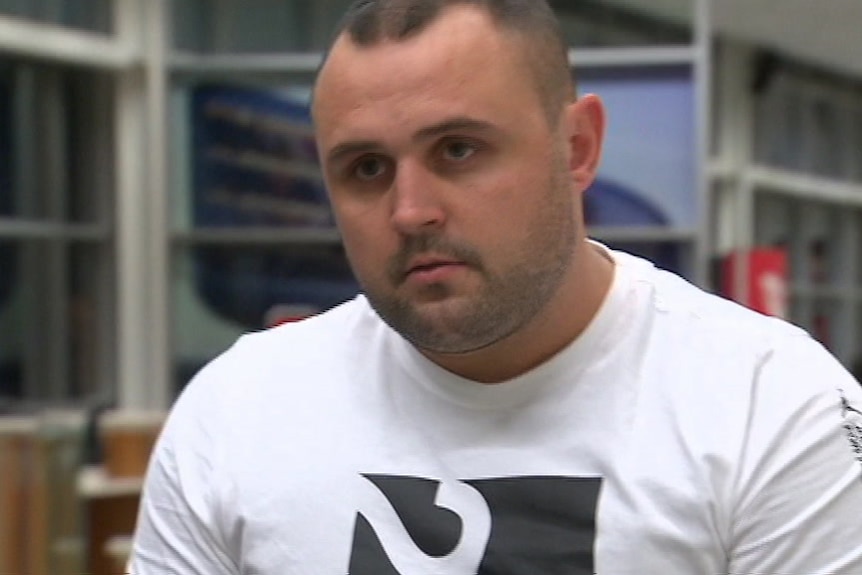 Kyle Pryde walking through the airport with a serious expression on his face.