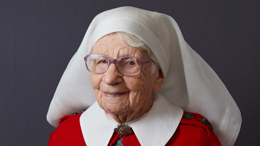 Portrait of an elderly woman in a nurse uniform wearing war medals