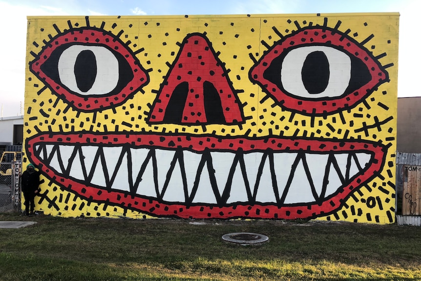 A mural of a large face showing his teeth