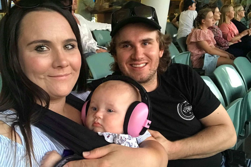 Sarah Lehman and partner Keta Balchin with daughter Londyn wearing earmuffs at the Ed Sheeran show.