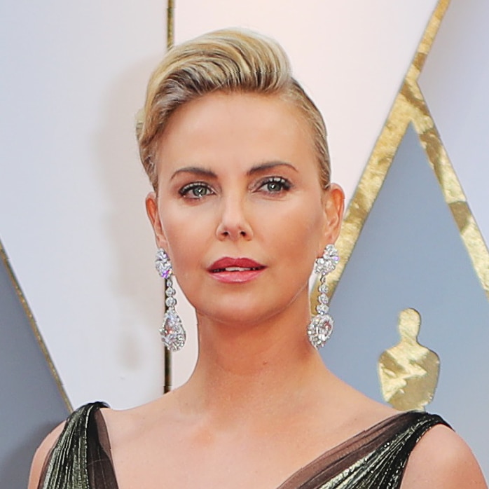 Charlize Theron wearing large drop diamond earrings and a metallic dress.