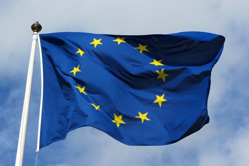 Drapeau de l'Union européenne contre un ciel bleu nuageux.