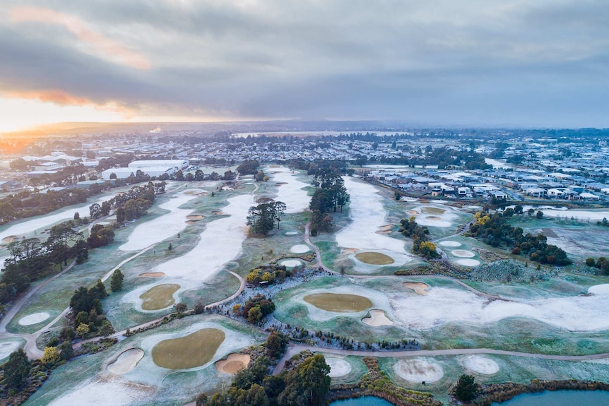 Golf course from above where the fairways are covered in snow or ice