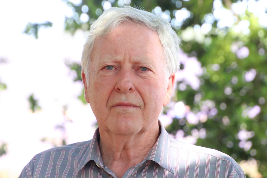 Robert Ravens stands under a tree.