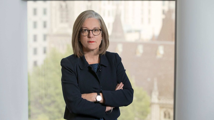 Karen Chester standing in an office with her arms folded.