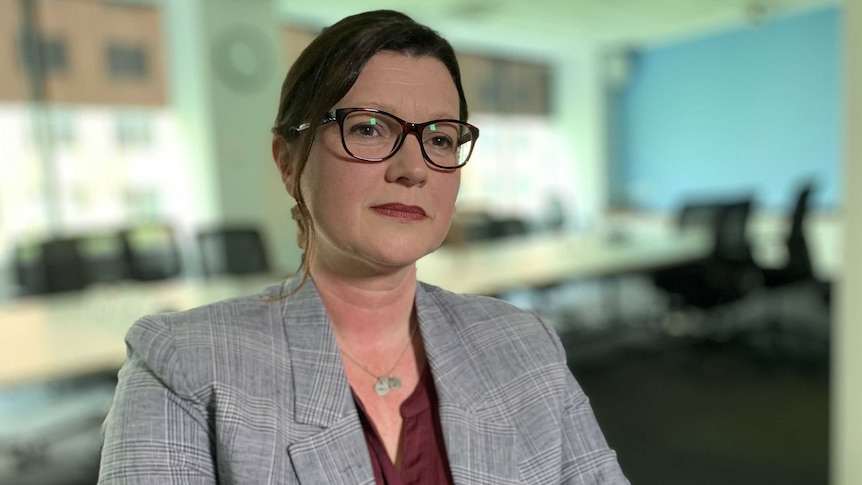 Julia Fox looking past the camera in an office environment