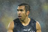 Eddie Betts plays AFL in pouring rain. He's wearing the Adelaide Crows' Indigenous heritage jersey.