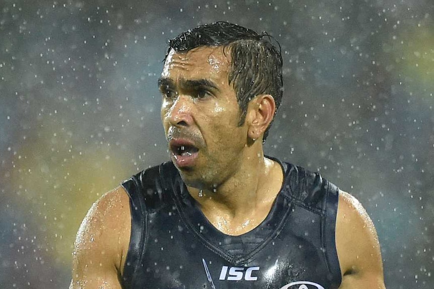 Eddie Betts plays AFL in pouring rain. He's wearing the Adelaide Crows' Indigenous heritage jersey.