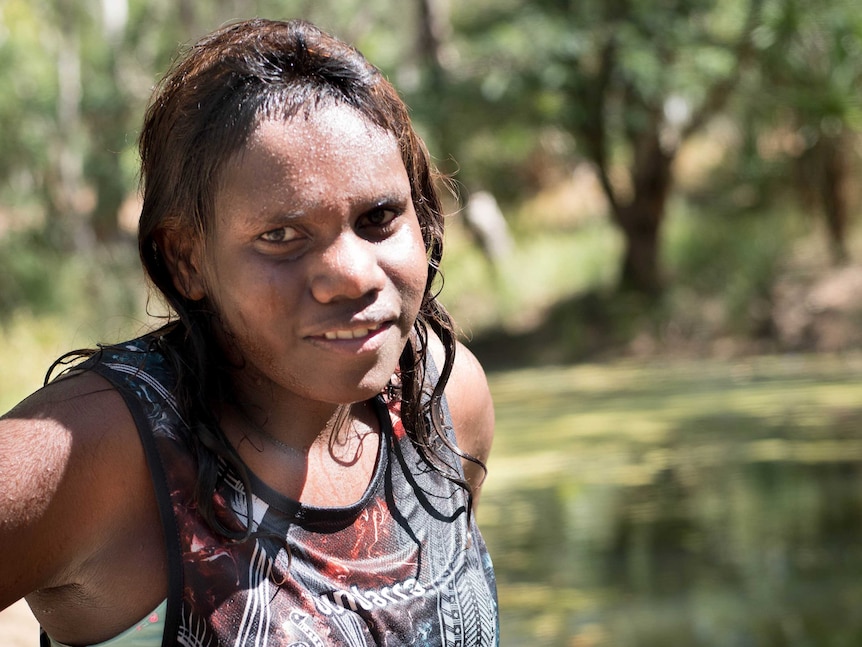 Young girl stands wet beside a swimming hole in a river at Yulumbu in the Kimberley.