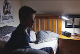 A sleepy teenager in his bedroom