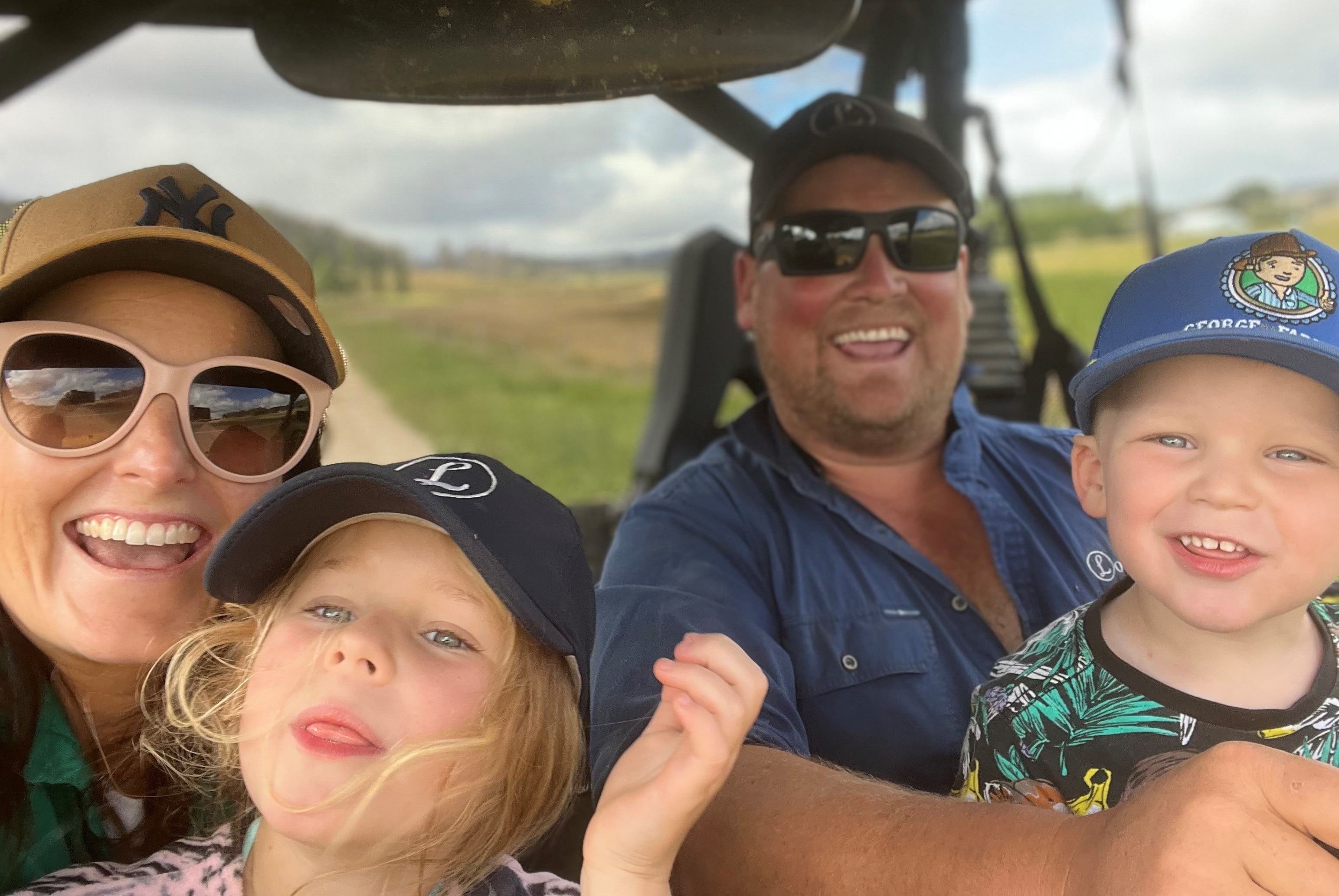 Family of four in a tractor cabin, smiling
