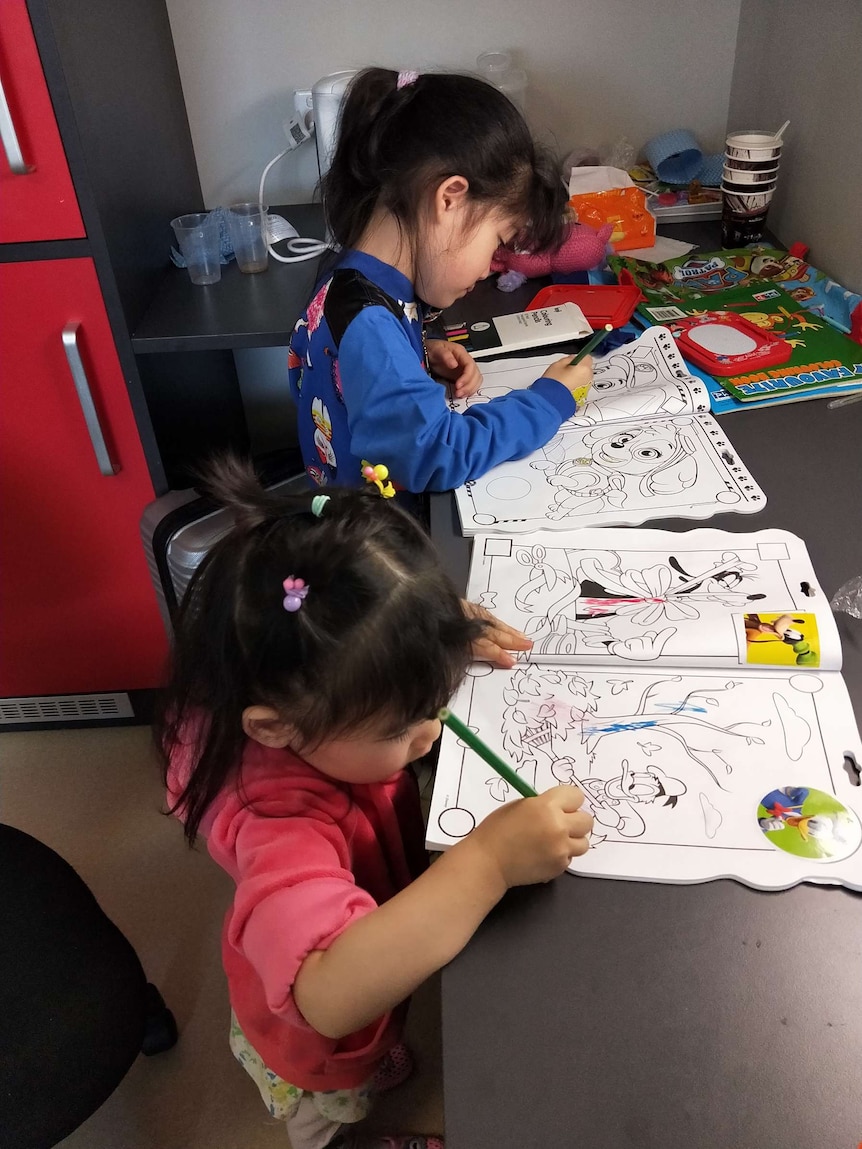 Angela and Bella draw in their room on the first day of quarantine.