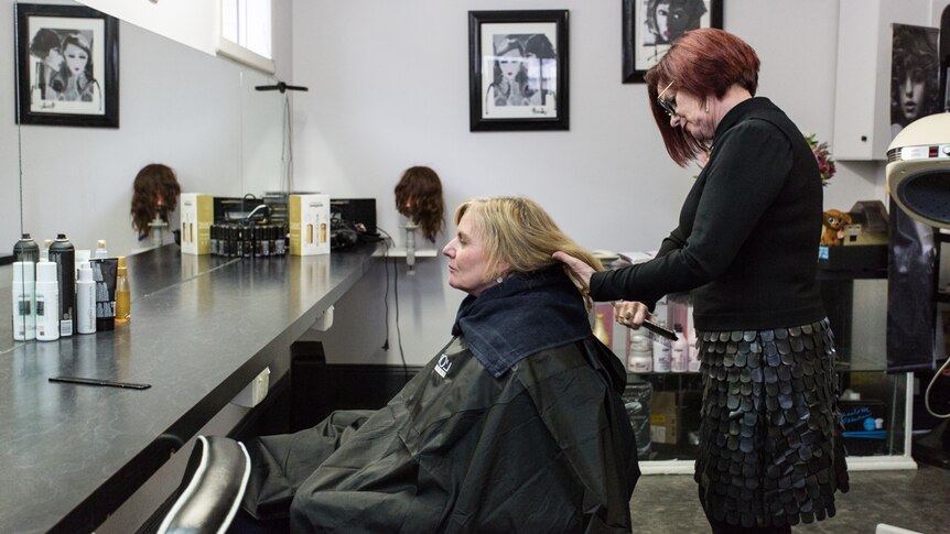 Hairdresser Gayle Emmett brushing the hair of her client.